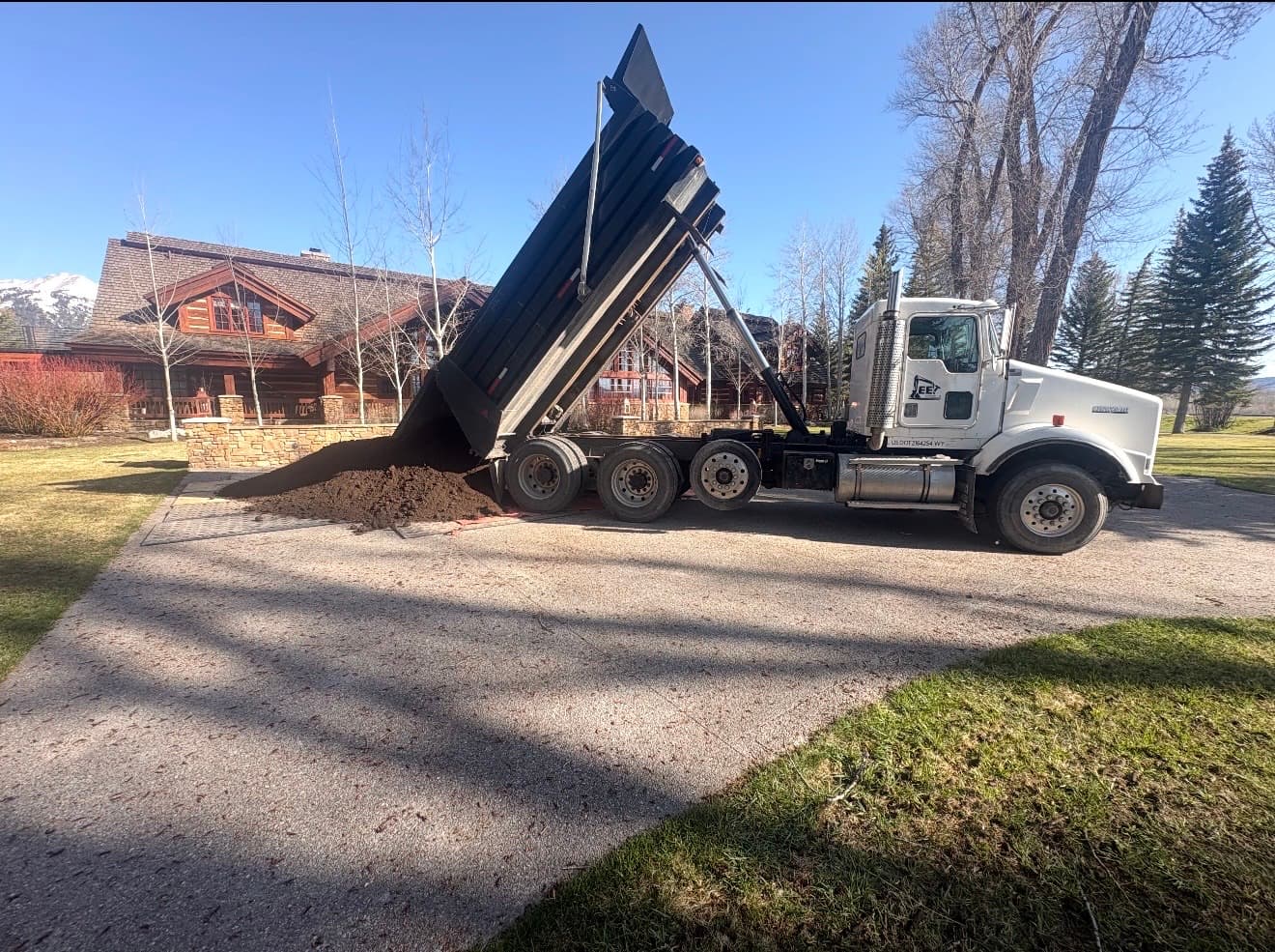 Dump truck delivering topsoil at a log home in Jackson, Wyoming